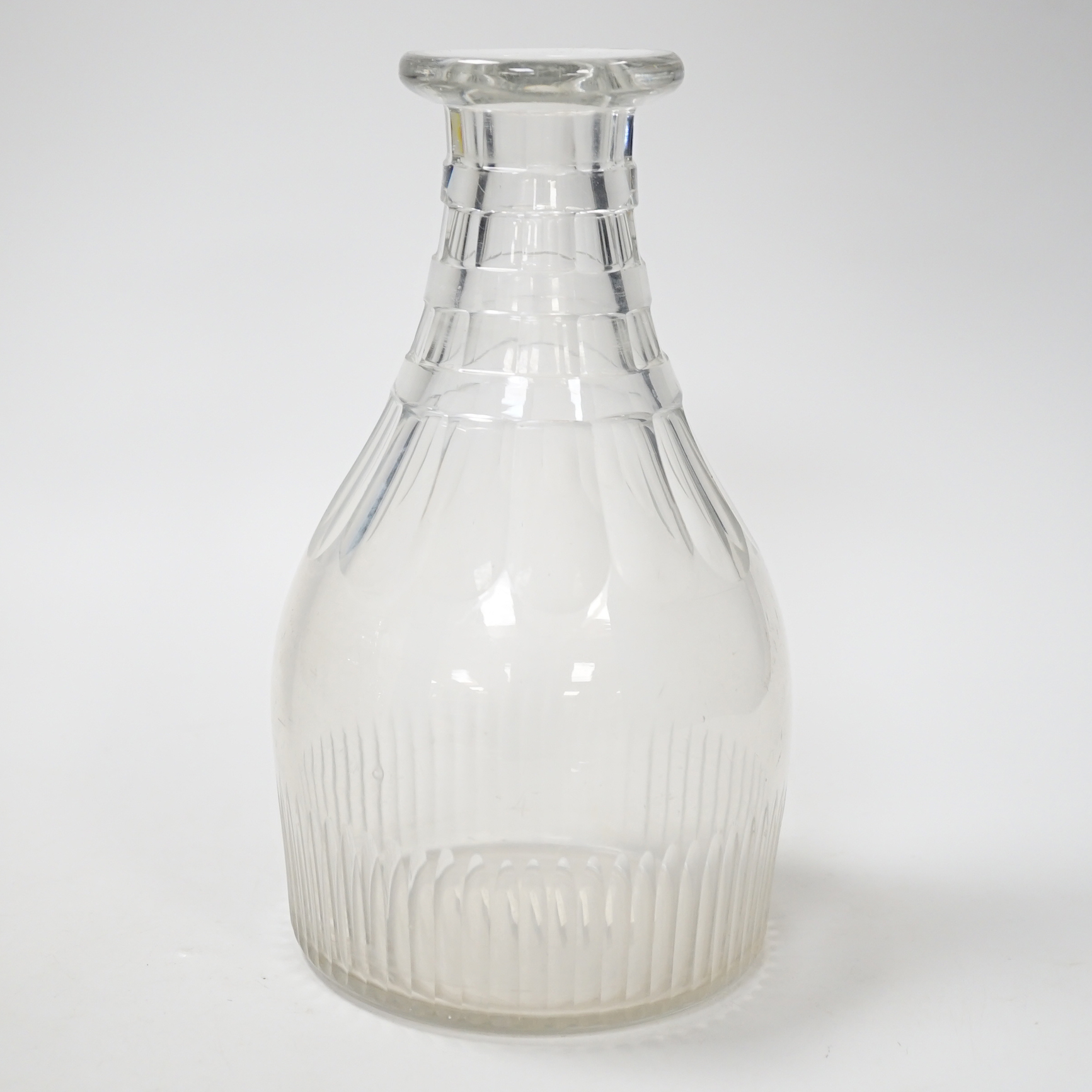 A rare English lead crystal Georgian carafe, c.1810-30, three rows of square cut facets replace earlier rings around neck followed by rounded facets and basal flutes, the base with ground and polished pontil, 22cm high